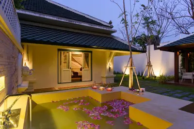 a house with a flower garden in front of it at Kalanan Riverside Resort in Nonthaburi