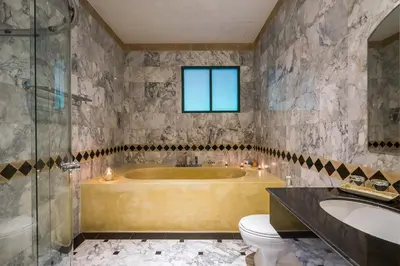 a bathroom with a tub and a toilet and a sink at Kalanan Riverside Resort in Nonthaburi
