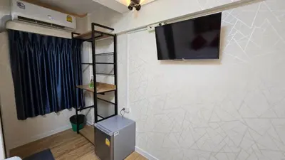 a living room with a tv on a wall at Khaosan Art Hotel in Bangkok