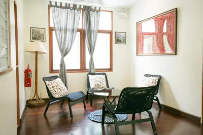 a living room with chairs and a table and a window at Greenery Hostel in Bangkok