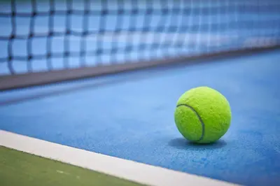 a green tennis ball sitting on a tennis court at Sivalai Place in Bangkok