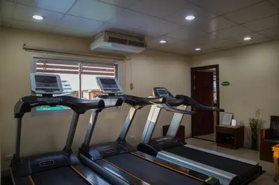 a gym with two treadmill machines in a room at Sivalai Place in Bangkok