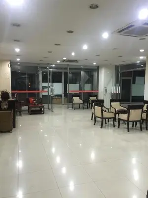 a large room with chairs and tables in a building at Mall Suites Hotel in Bangkok