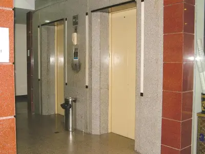 a hallway with two doors and a silver pole at Mall Suites Hotel in Bangkok