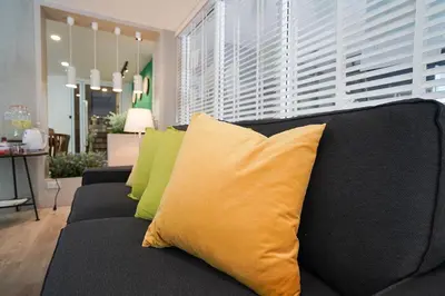 a black couch with yellow pillows in a living room at Hap@sathorn in Bangkok