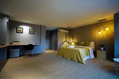 a bedroom with a bed and a desk and lights at Hap@sathorn in Bangkok