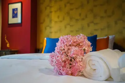 a bunch of pink flowers sitting on top of a bed at Hap@sathorn in Bangkok
