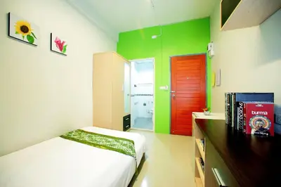 a bedroom with green and red walls and a bed at Smile Inn in Bangkok