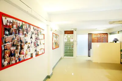 a hallway with pictures on the walls of a building at Smile Inn in Bangkok