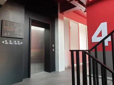 a elevator in a building with a red wall at Penpark Place in Bangkok