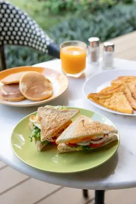 a table with two plates of food and a sandwich and chips at Penpark Place in Bangkok