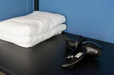 a table with a hair dryer next to a bed at Penpark Place in Bangkok