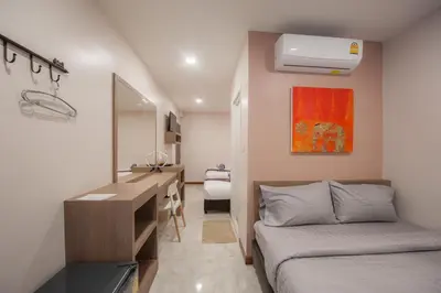 a bedroom with a desk and a bed and a sink at The Moon Night Hotel in Bangkok