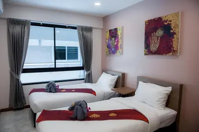a hotel room with two beds and a window at The Moon Night Hotel in Bangkok