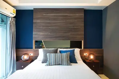 a bedroom with a large bed with blue walls at NW Apartment Lasalle 59 in Bangna