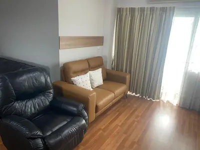 a living room with a leather couch and a chair at Penthouse by JJ in Bangkok