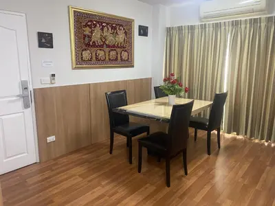 a dining room table with chairs and a painting on the wall at Penthouse by JJ in Bangkok