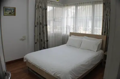 a bed with white sheets and pillows in a bedroom at Penthouse by JJ in Bangkok
