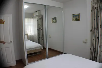 a mirror in a room with a bed and a bedroom at Penthouse by JJ in Bangkok