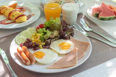 a plate of food with eggs and vegetables on a table at Nonthaburi Palace Hotel in Nonthaburi