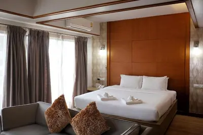 a hotel room with a bed and a couch at Nonthaburi Palace Hotel in Nonthaburi