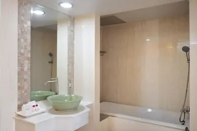 a bathroom with a bowl sink and a tub at Nonthaburi Palace Hotel in Nonthaburi