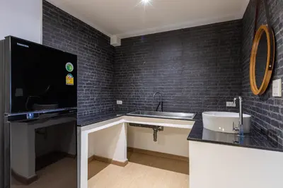 a bathroom with a sink and a black tiled wall at Siam Star Hotel in Bangkok