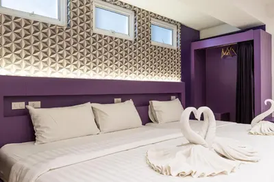 a bedroom with a bed with two swans on it at Siam Star Hotel in Bangkok