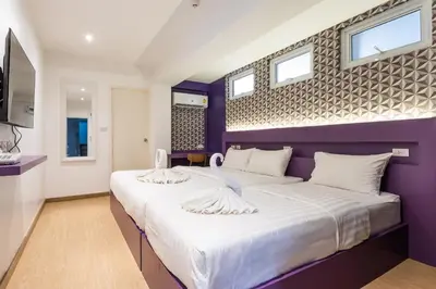 a purple bedroom with two swans on a bed at Siam Star Hotel in Bangkok