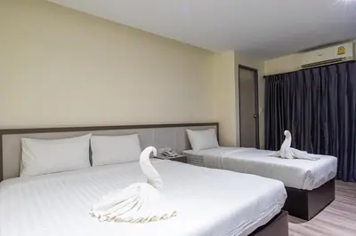 two beds in a hotel room with swans on them at Siam Star Hotel in Bangkok