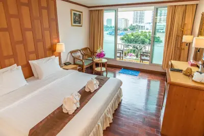 a hotel room with a large bed and a large window at New Siam Riverside in Bangkok