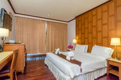 a hotel room with a bed with two towels on it at New Siam Riverside in Bangkok