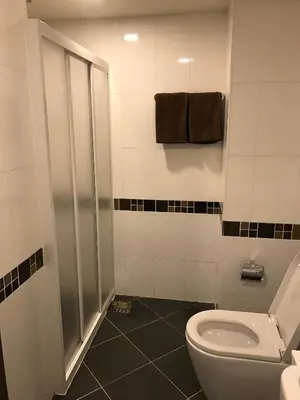 a bathroom with a toilet and a shower at Central Mansion in Bangkok