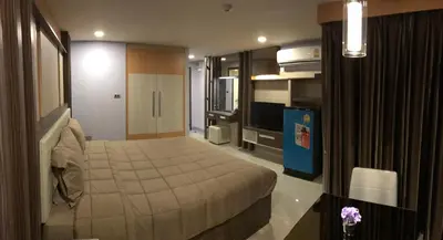 a hotel room with a bed and a television at Central Mansion in Bangkok