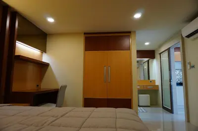 a bedroom with a bed and a desk and a cabinet at Central Mansion in Bangkok