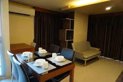a dining room with a table and chairs and a chair at Central Mansion in Bangkok
