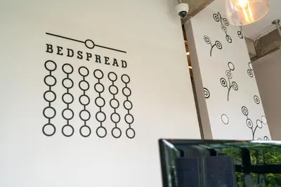 a wall with a sign that reads bed spread at Bedspread Hostel in Bangkok