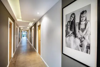 a hallway with a picture of two girls on the wall at Narra Hotel in Bangkok