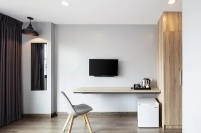 a living room with a table and a chair at Narra Hotel in Bangkok