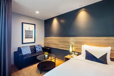 a hotel room with a bed and a couch at Narra Hotel in Bangkok