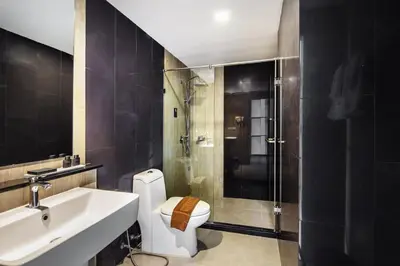 a bathroom with a toilet and a sink and a shower at Narra Hotel in Bangkok