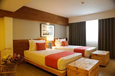 a hotel room with two beds and a window at Nandha Hotel in Bangkok