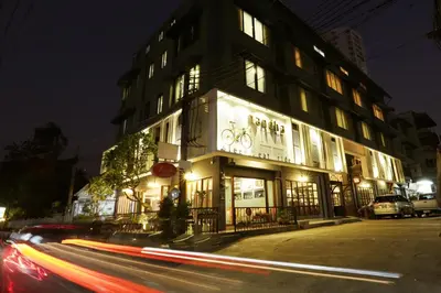 a building on a city street at night with cars at Nandha Hotel in Bangkok