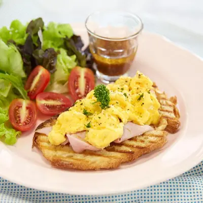 a plate of food with a sandwich and a salad at Nandha Hotel in Bangkok