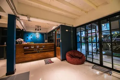 a lobby with a red chair and blue walls at 4SHARE Hostel in Bangkok