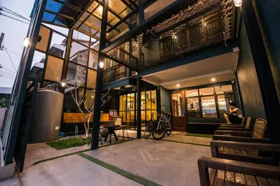 a man sitting on a bench outside of a building at 4SHARE Hostel in Bangkok