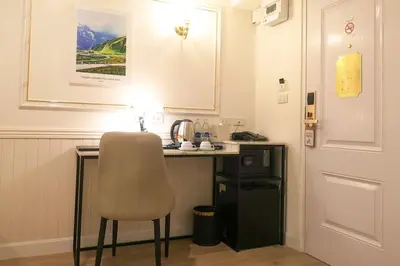 a small kitchen with a desk and a chair at Travelier Hostel in Bangkok