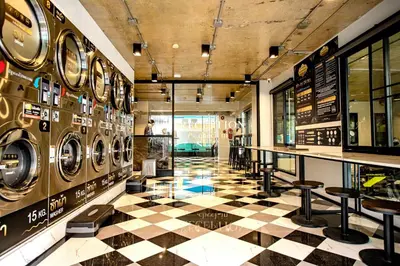 a room with several washing machines and a checkered floor at Travelier Hostel in Bangkok