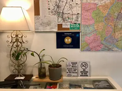 a table with a lamp and a map on a wall at 12/14 HOME Studio in Bangkok
