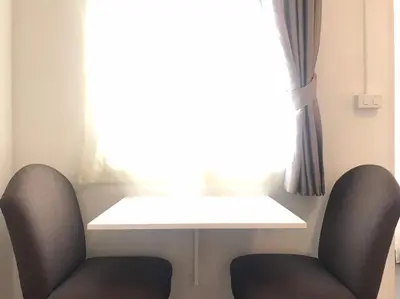 a table and two chairs in front of a window at 12/14 HOME Studio in Bangkok